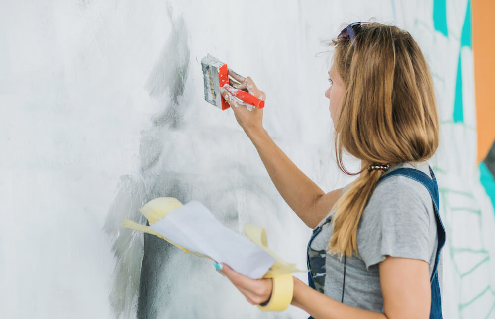 Malerarbeiten an einem Deko-Bild an der Wand